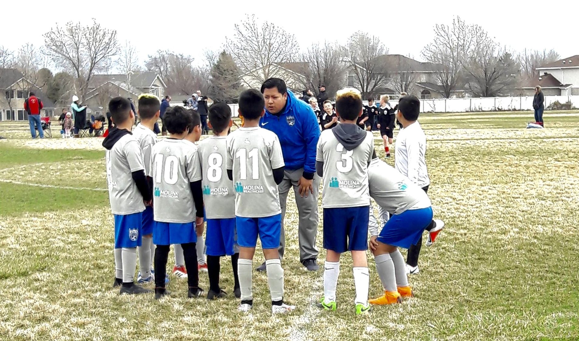 Coach talking to young soccer players on field
