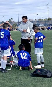 Carlos on field talking to youth soccer players